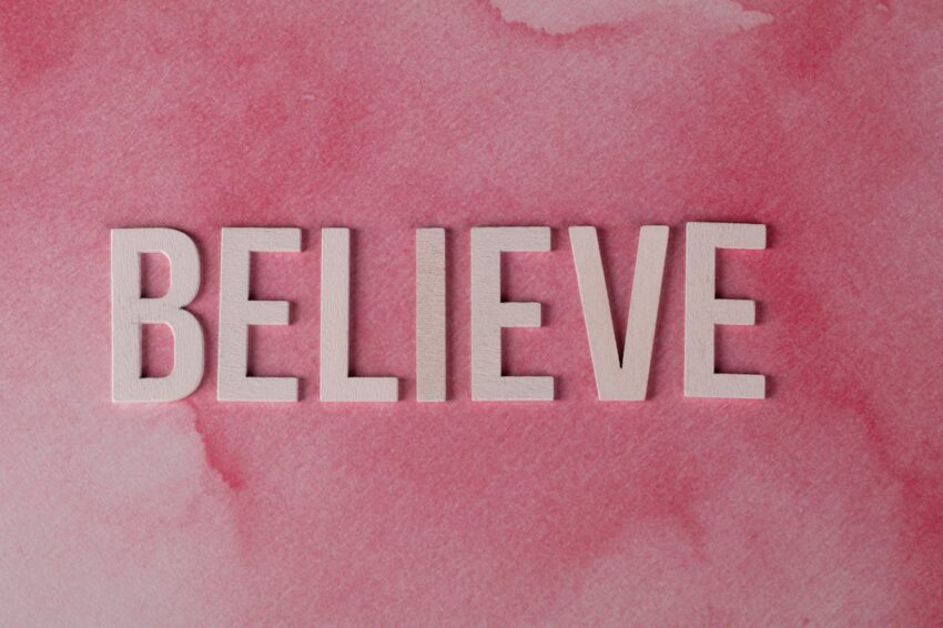 The word believe on a pink background